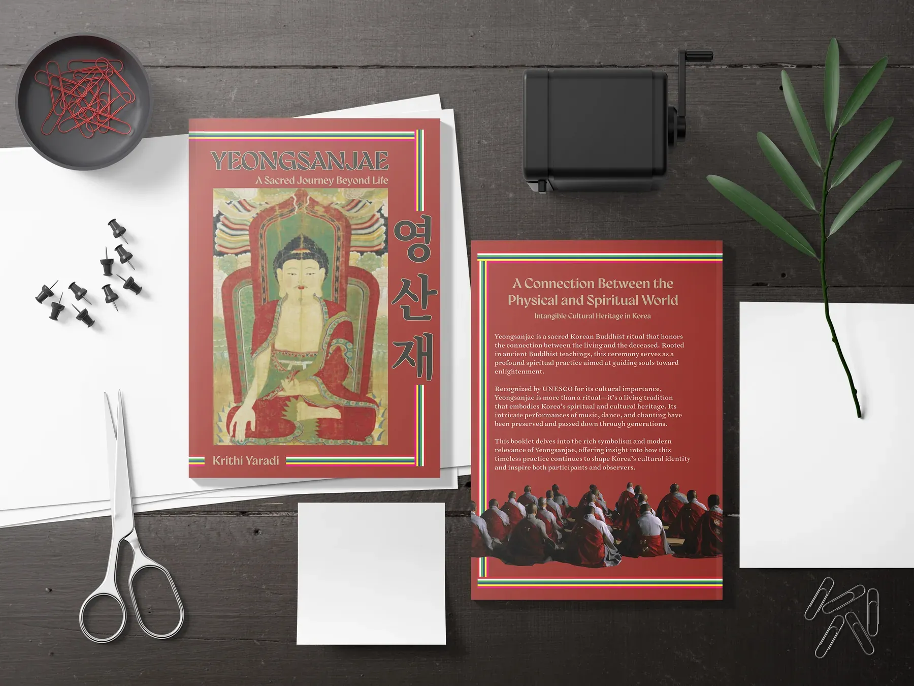 The booklet laid out on a desk with scissors and pins